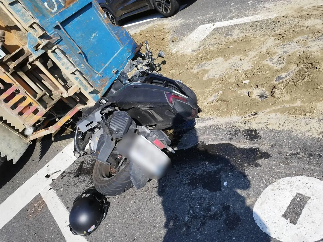 一輛砂石車疑似煞車不及，追撞前方停等紅燈的3輛車後翻覆，車斗壓住一輛機車。（圖／翻攝畫面）