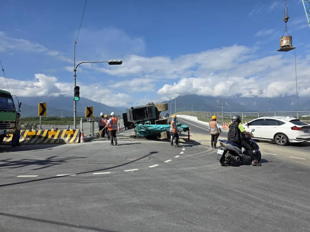 花蓮大橋南端23日中午發生一起拖板車運載怪手翻落的意外,造成南下方向交通受阻近兩小時。(圖/翻攝畫面)