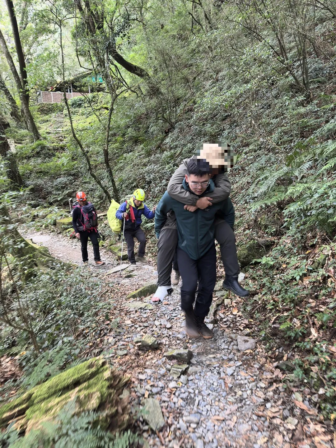 救難人員將傷者背負至檜谷山莊。（圖／屏東縣政府消防局提供）