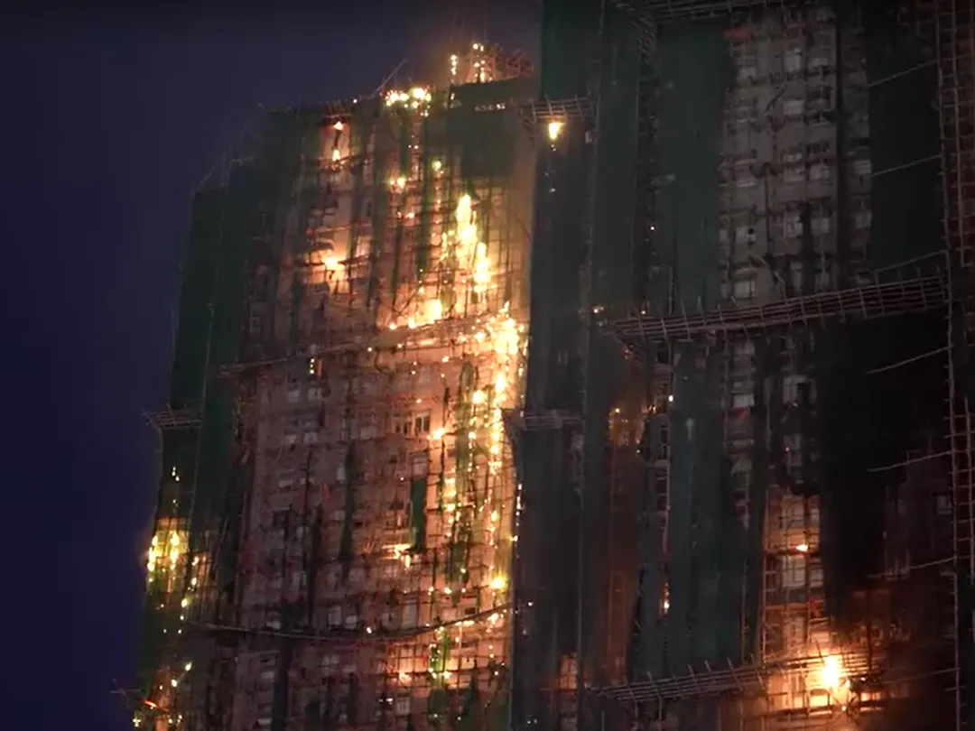 現場畫面可看到包圍建物外部的竹編鷹架陷入火海。（圖／路透社）
