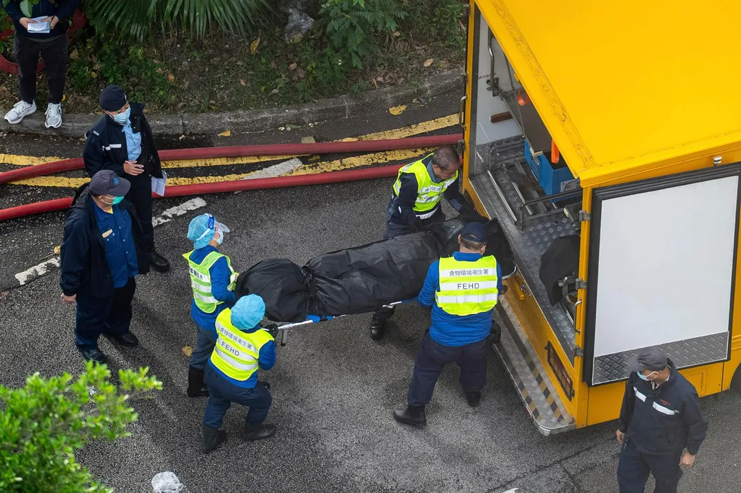 救援人員27日從火場抬出一具遺體。(圖/美聯社)