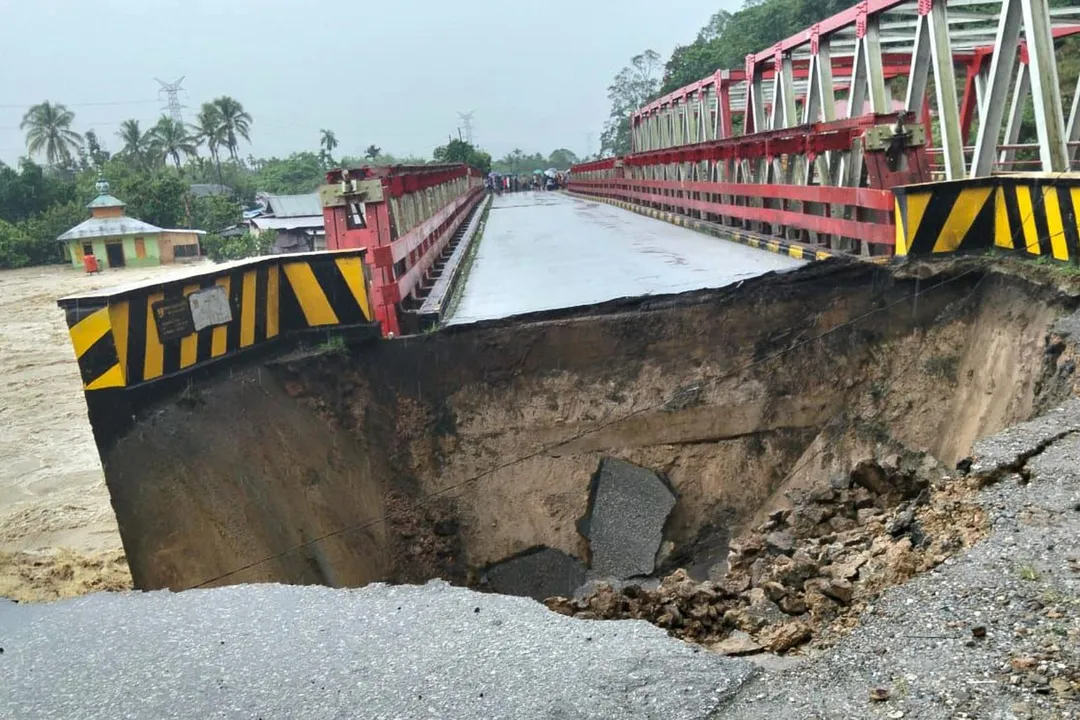 印尼蘇門答臘島近日遭暴雨及土石流侵襲，救難人員今天加緊腳步，趕赴災區將受困在湍急泥流中的居民救出。（圖／美聯社）