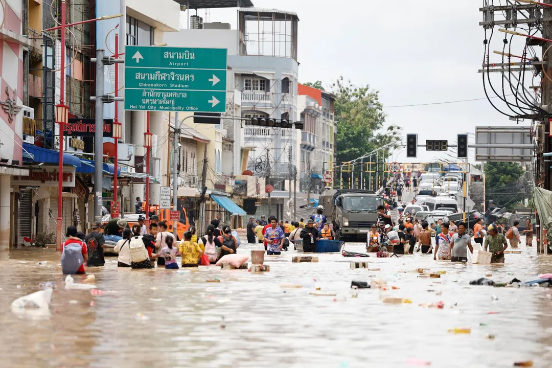 11月27日,泰國南部宋卡府(Songkhla),人們在洪水中跋涉。(圖/美聯社)