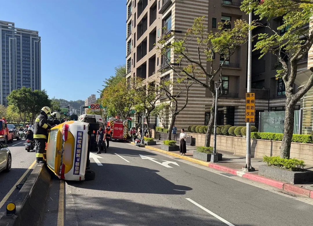 台北市文山區文山二分局前發生一起小黃翻車事故，消防人員到場進行救援。（圖／警方提供）