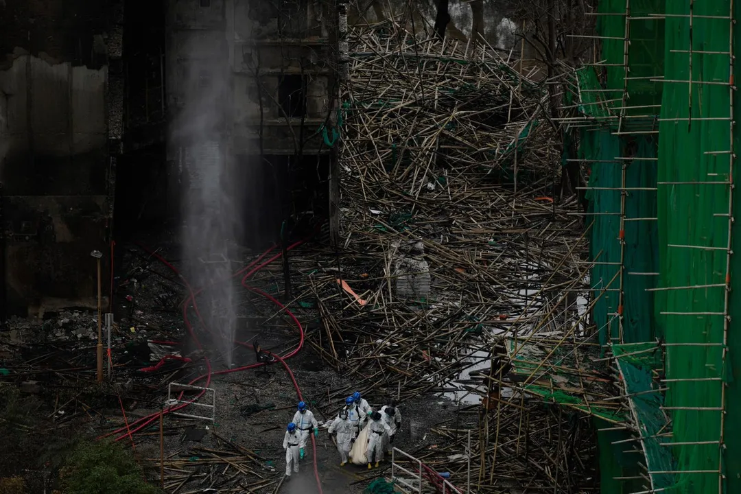 緊急救援人員從宏福苑火災現場移走疑似遺體。（圖／美聯社）