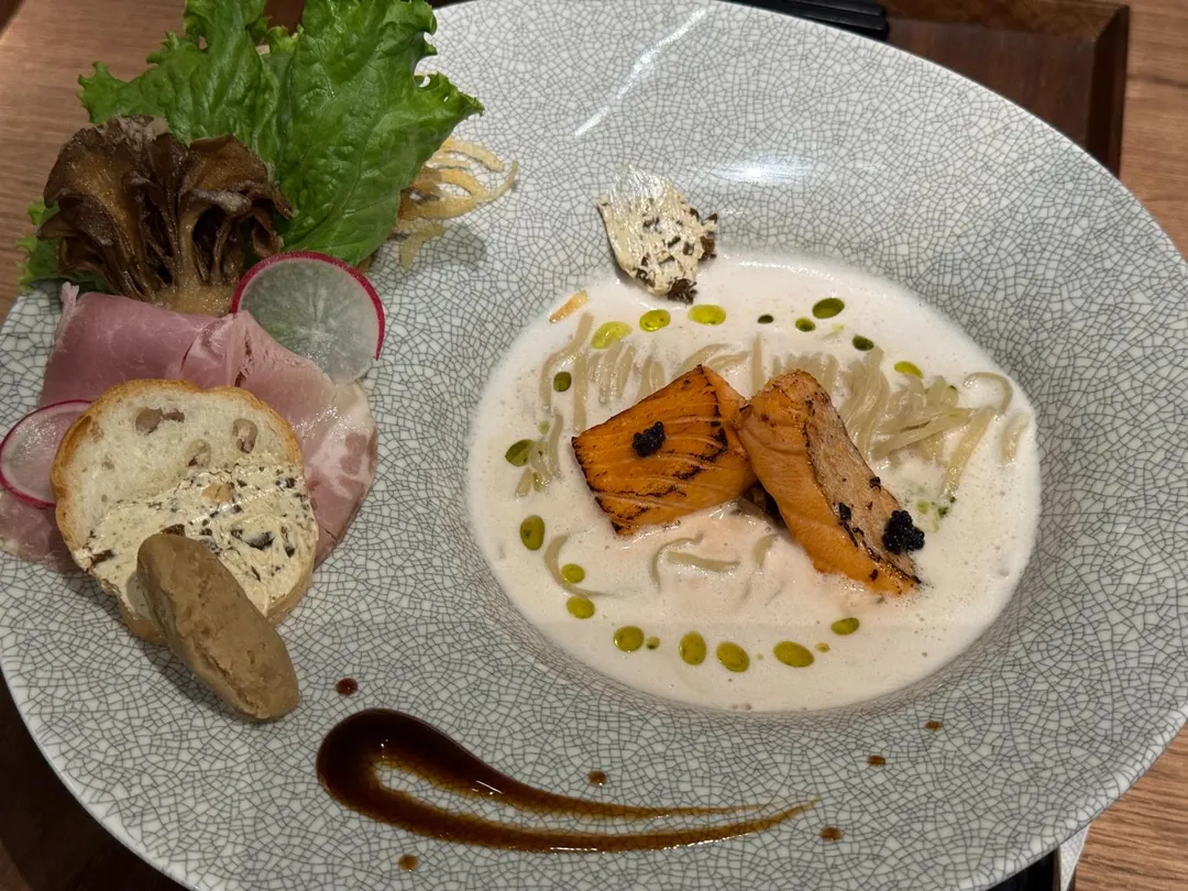 牛肝蕈鮭魚拉麵附上白酒，結合歐式、日式料理風格。（圖／黃宏輝提供）