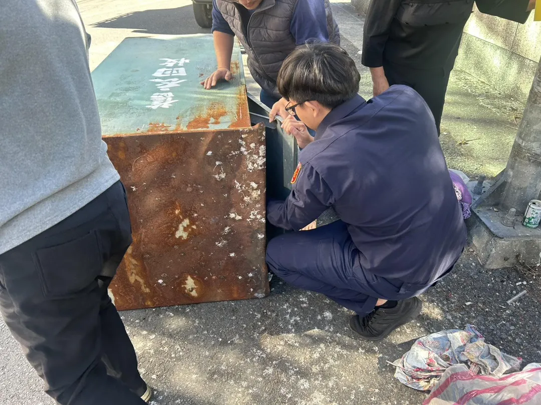 三人反覆嘗試、汗水淋漓，最終以徒手從回收箱深處拖出西裝褲。（圖／警方提供）