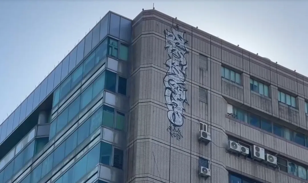 專業人士研判，塗鴉客最可能在夜深人靜時潛入大樓頂樓，採取「攀降垂降」方式，利用繩索或專業固定裝備在高空進行橫向移動創作。（圖/翻攝畫面）