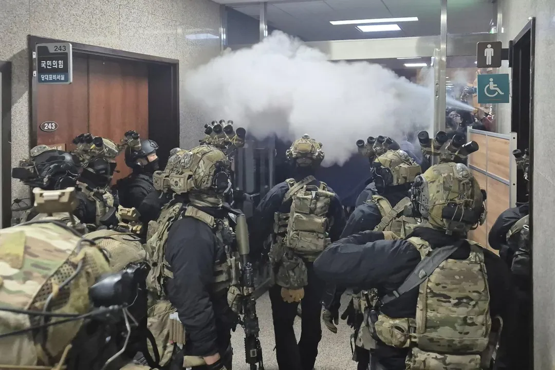圖為尹錫悅祭出戒嚴令後，國會工作人員噴灑滅火器阻止士兵進入。（圖／美聯社）