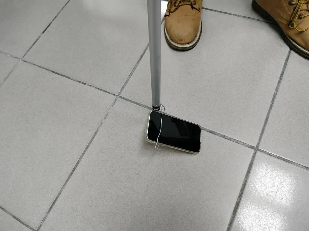 黃班長以鐵線繞圈自製手機救援工具。(圖/台中市政府環境保護局)