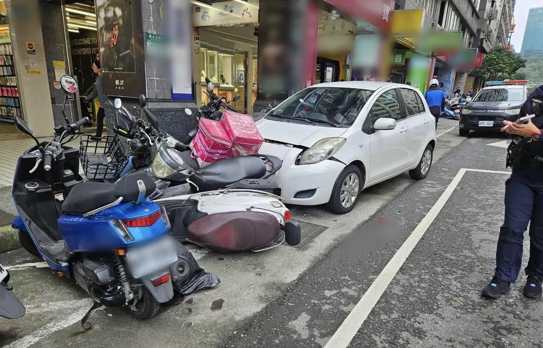 白色自小客車撞翻路邊17台機車。（圖／翻攝畫面）