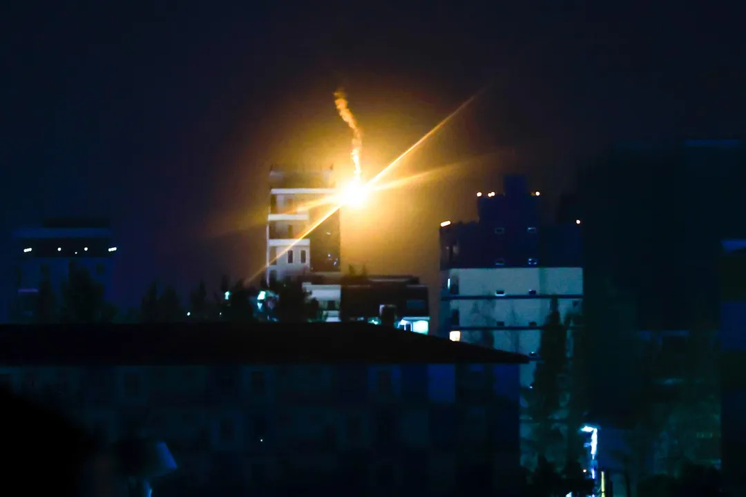 圖為12月26日,泰國軍方發射的照明彈劃過柬埔寨波貝(Poipet)的天空。(圖/美聯社)