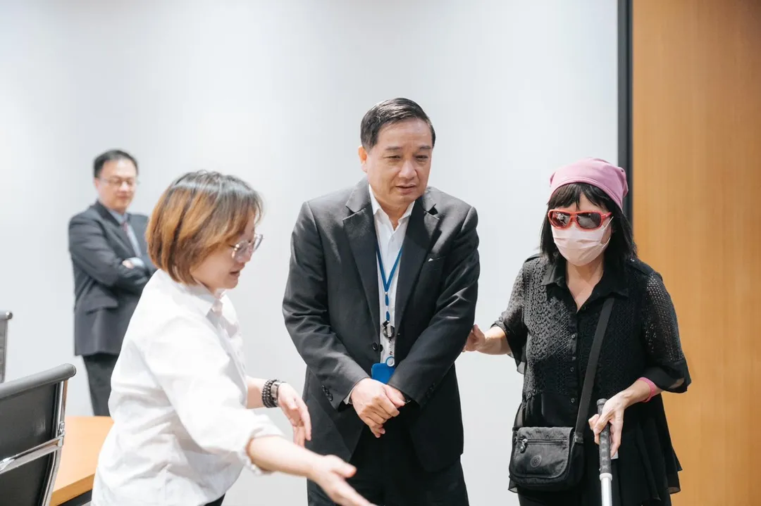 中信銀行董事王正新（右二）受邀擔任訪員與視障體驗員（右一）進行情境模擬訓練。（圖／中信銀行提供）