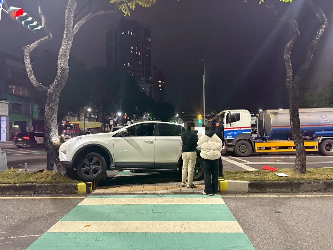 轎車遭撞衝上分隔島。(圖/警方提供)
