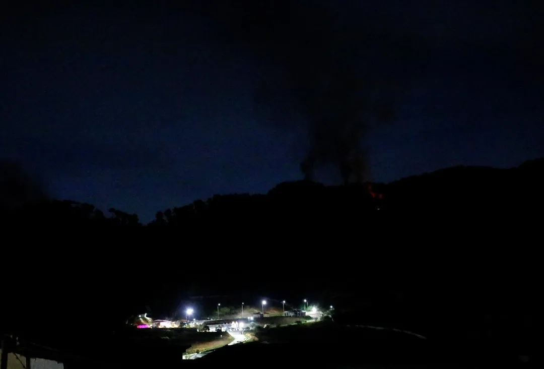 1月3日，加拉加斯的軍事區蒂烏納堡（Fort Tiuna）附近升起濃煙，當地處於全面停電狀態。（圖／路透社）