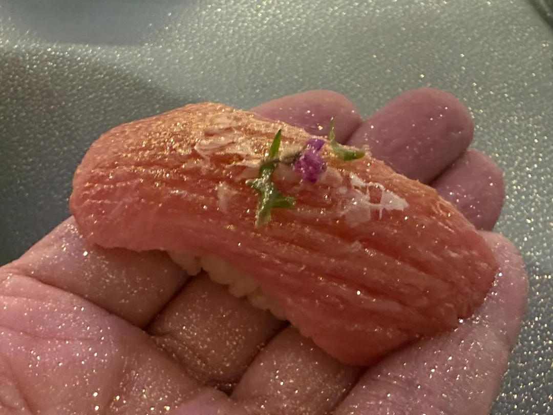 黑鮪魚大腹肉現場煙燻,僅使用淡雪鹽、紫蘇花輕柔點綴,撒上金箔粉星輝點點。(圖/黃宏輝提供)