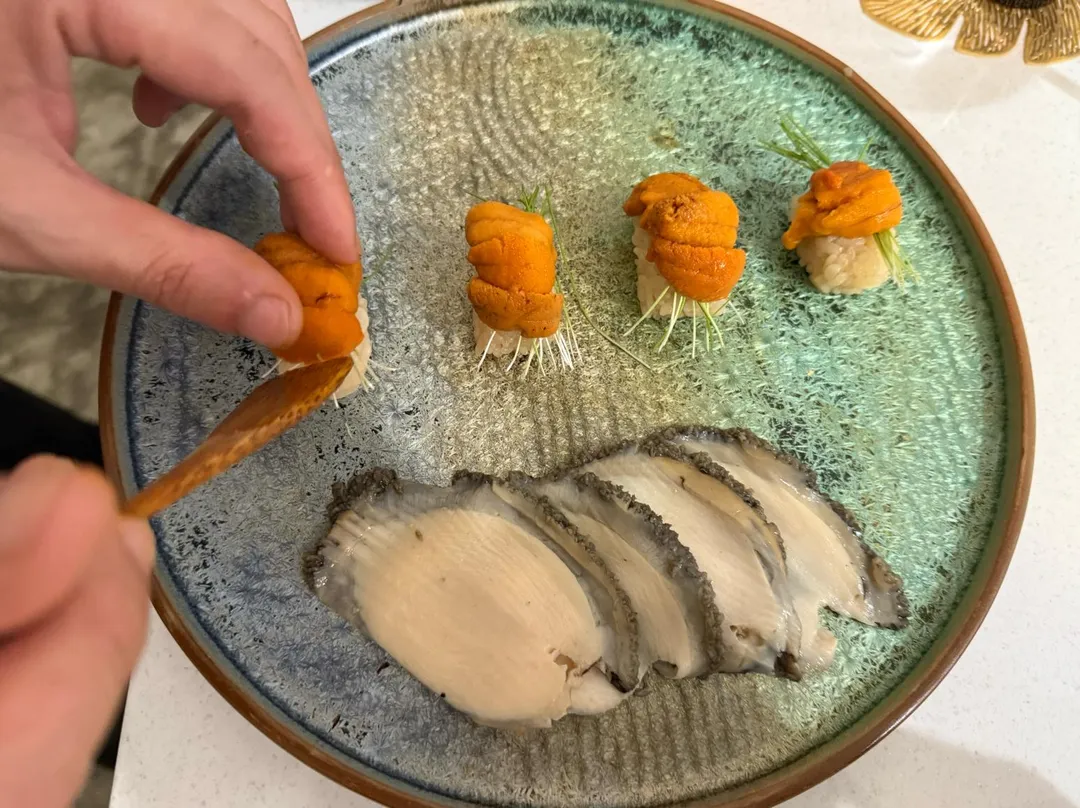厚厚鮑魚片取代海苔，包住海膽芽蔥醋飯。（圖／黃宏輝提供）