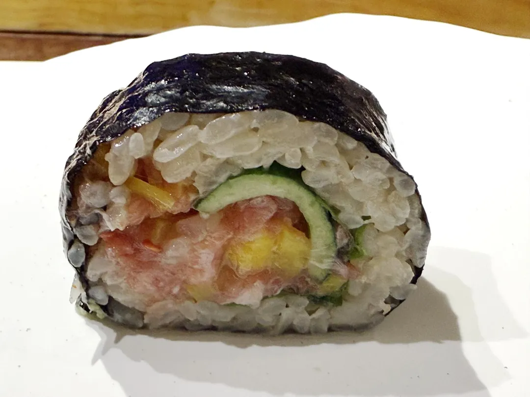 芝麻、紅蘿蔔與蔥花撒上鮪魚赤身、金三角大腹肉泥捲成壽司。（圖／黃宏輝提供）