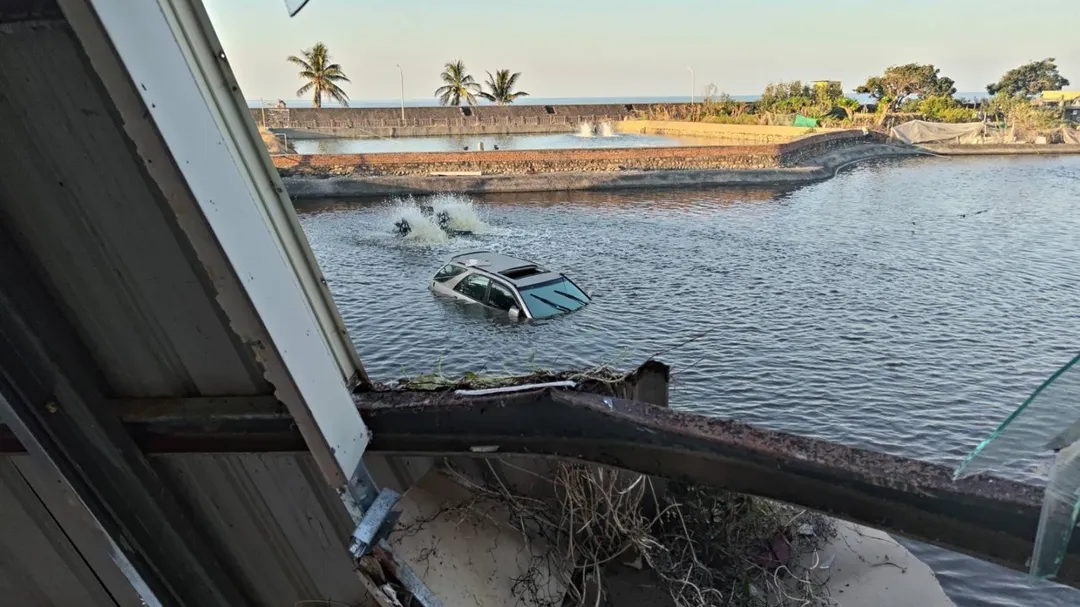 有民眾發現轎車就在魚塭中載浮載沉，這才發現原來是從餐廳衝出來的。（圖／中天新聞）