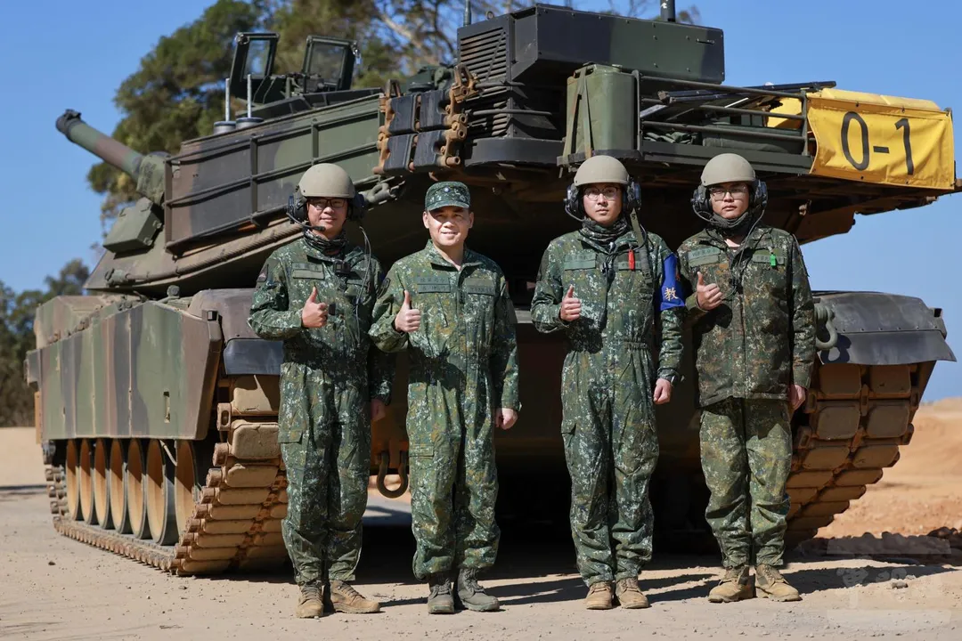 陸軍司令呂坤修(圖左二)親自參與M1A2T戰車實彈射擊。注意他穿著的裝甲兵數位迷彩連身服，胸前拉鍊處仿效美軍軍服以魔鬼粘佩掛3星上將階級。(圖/陸軍司令部)