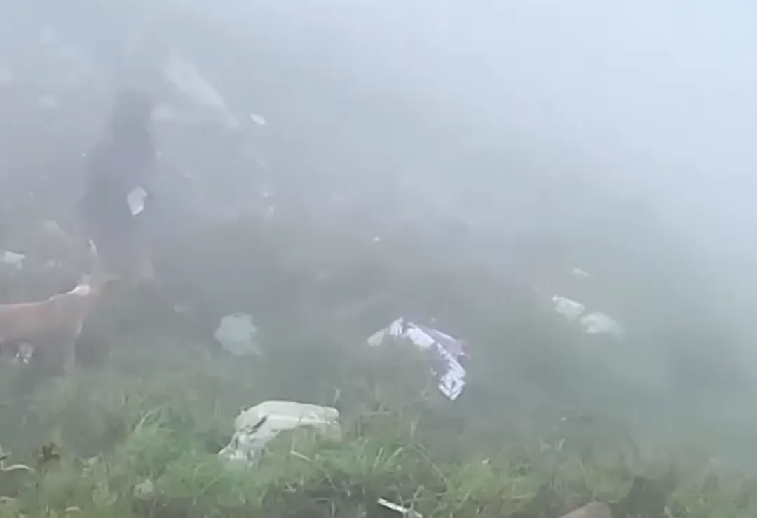 從大霧濛濛的失事地點依稀可見到地上的飛機殘片。（圖／路透）