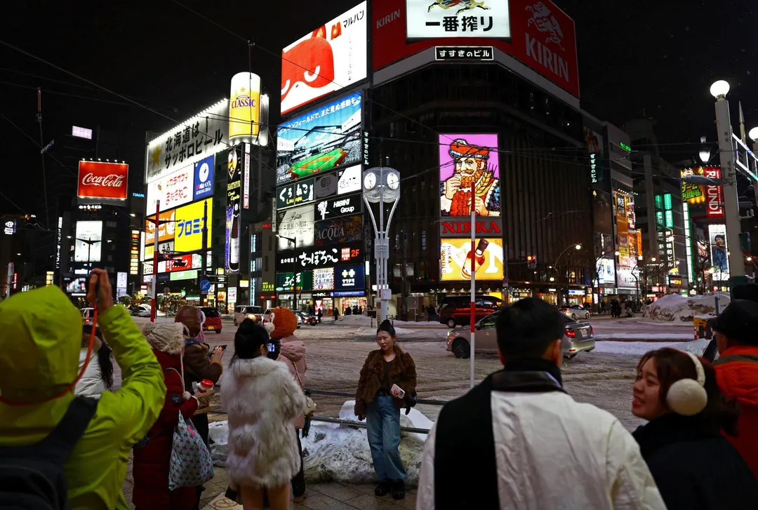 圖為1月18日，外國遊客在北海道札幌拍照留念。（圖／路透社）