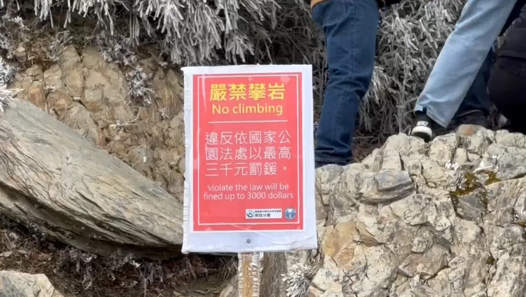 近期部分遊客為了拍攝「網美照」，無視安全規範，冒險攀爬武嶺亭後方的陡峭山壁。（圖／太管處提供）
