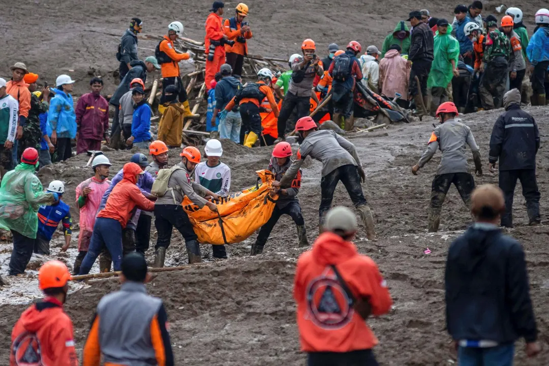 救難人員從土石中搬運屍袋，目前已有至少7人、83人失蹤。（圖／路透）