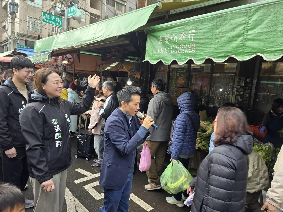 總統府副秘書長何志偉24日和市議員張曉昀及魏筠、彭俊豪議員辦公室主任等人在桃園忠貞市場掃街向市民獻上新年祝福，與民眾熱情互動。(圖/民眾提供)