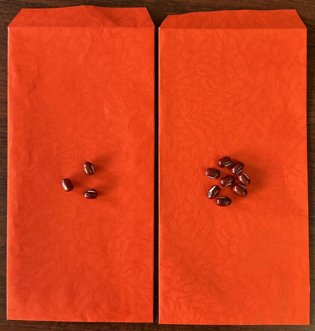 準備2個紅包，紅包一個包3顆紅豆，另一個包8顆紅豆，分開放在左右口袋，或一起放在錢包裡。（圖／楊登嵙提供）
