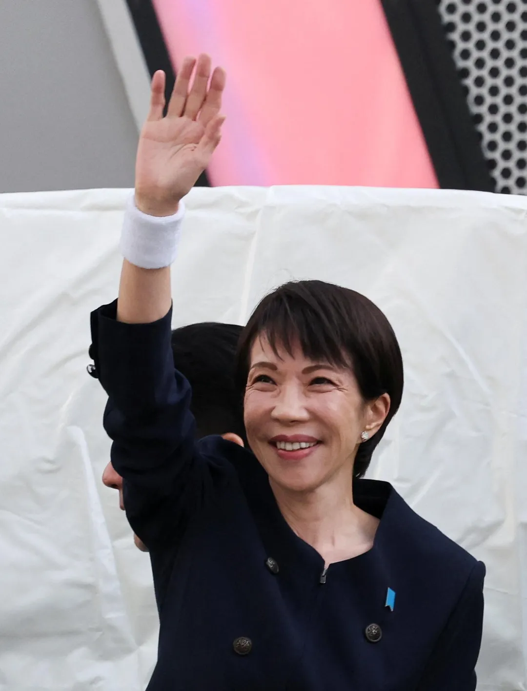 高市早苗近日在街頭拜票時戴著護腕。（圖／路透社）