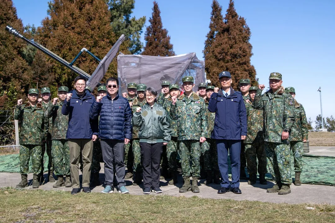 蕭美琴與空軍官兵合影，背後可見架設無人機防護網的35快砲。(圖/軍聞社)