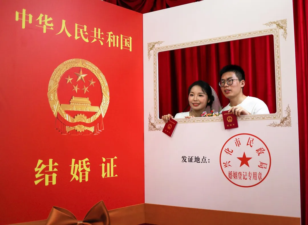圖為2025年七夕情人節，一對新人在江蘇興化民政局婚姻登記處領取結婚證後拍照。（資料照／新華社）