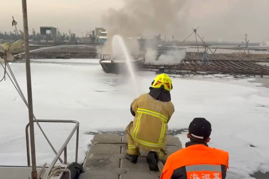 海巡人員和警消將起火漁船拖離現場，持續射水降溫避免悶燒復燃。（圖／翻攝畫面）