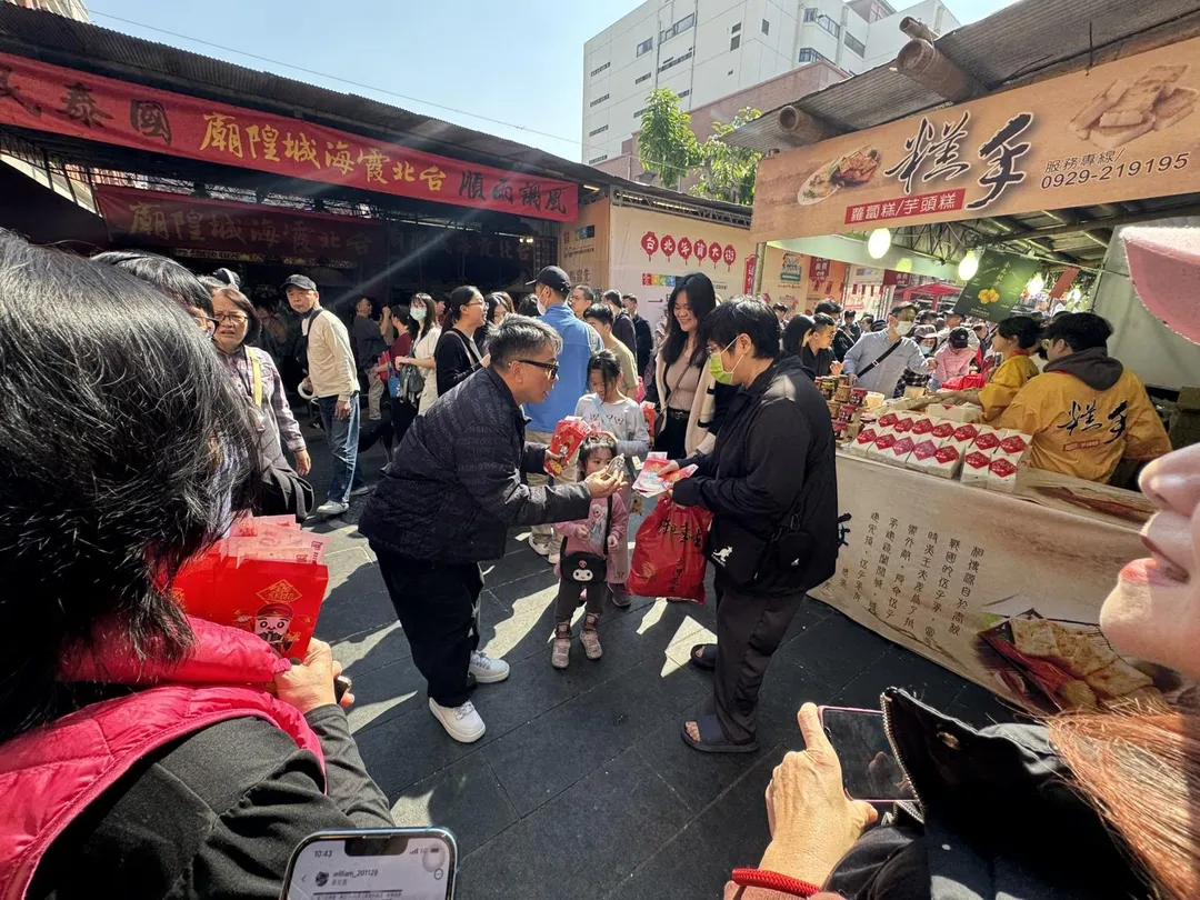 命理大師詹惟中在全台最靈驗的媒人廟台北霞海城隍廟前廣場，發放限量紅包。（圖／民眾提供）