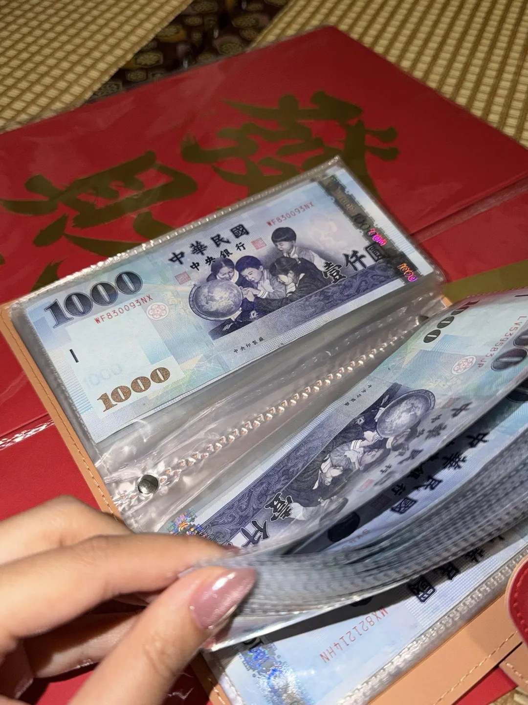Timmy曬出老公送的過年紅包,幽默形容收到「一本5公分厚的書」,實際上是用透明活頁冊裝滿千元鈔票。(圖/翻攝一起趣蕉游 臉書)