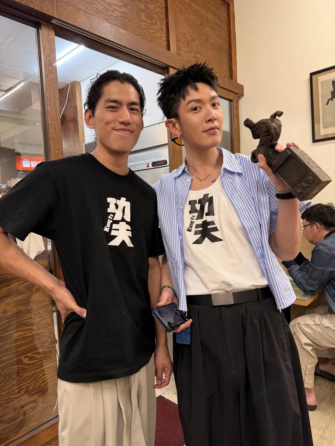柯震東（右）拿起朱軒洋（左）在火災中被燒焦、成為「黑色限量版」的金馬獎座。（圖／翻攝threads giddens9）
