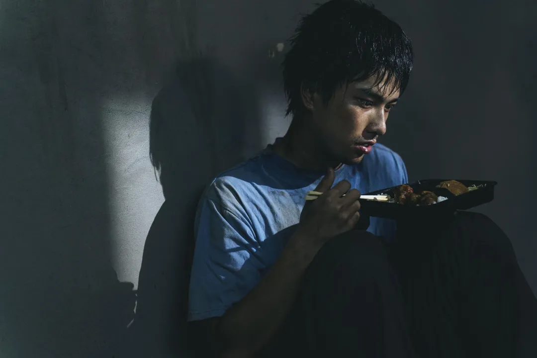 曾敬驊滿身污漬蜷縮紙板，球棒男凶狠逼近畫面曝光。（圖／「冬候鳥電影」 、「文策院」提供）