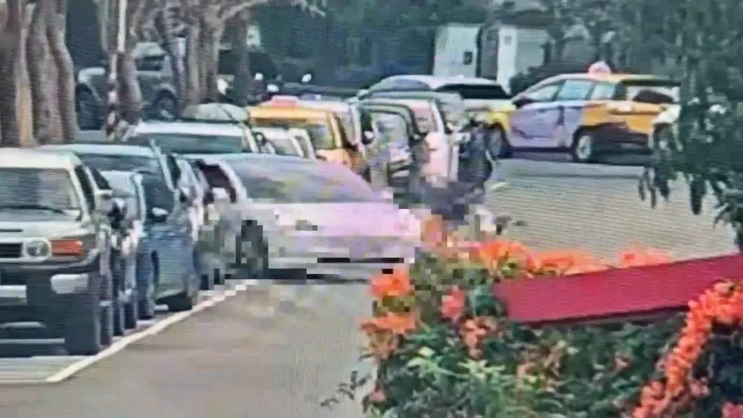 台北美國學校附近,51歲女重機騎士在中山北路遭停車格起駛的自小客車擦撞,導致右腿骨折。(圖/翻攝畫面)