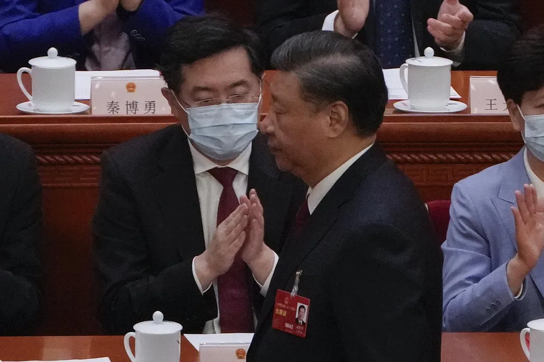 2023年3月13日，大陸十四屆全國人大一次會議閉幕，習近平走過秦剛。（圖／美聯社）