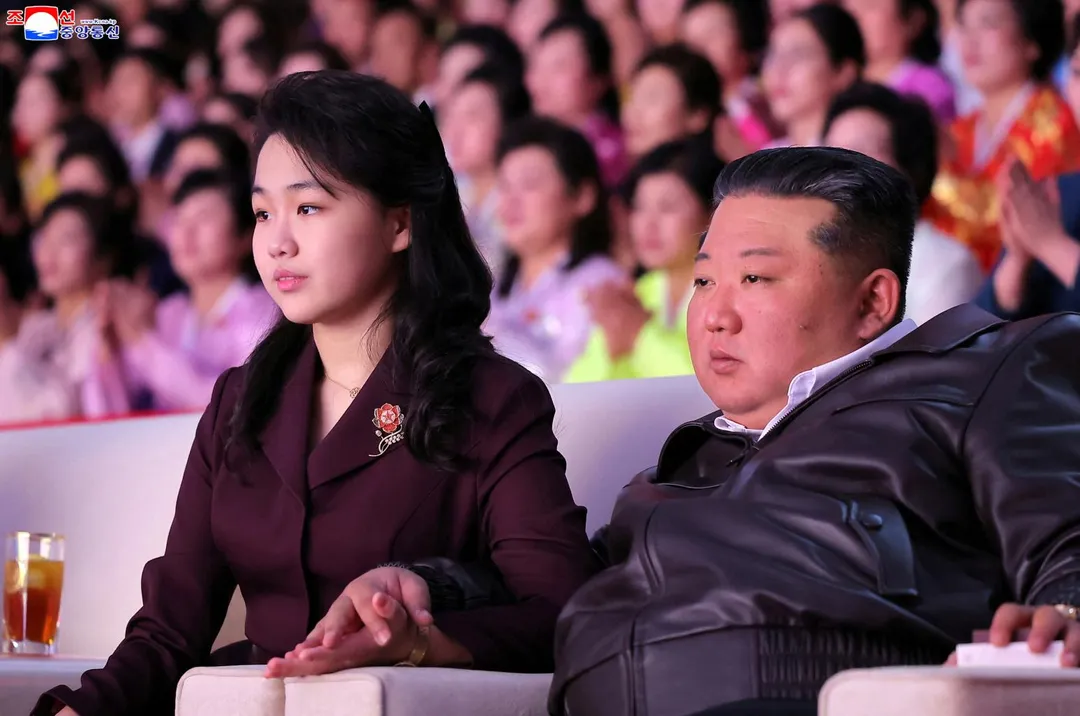 金正恩牽著金主愛的手一同觀看演出。（圖／《路透社》）
