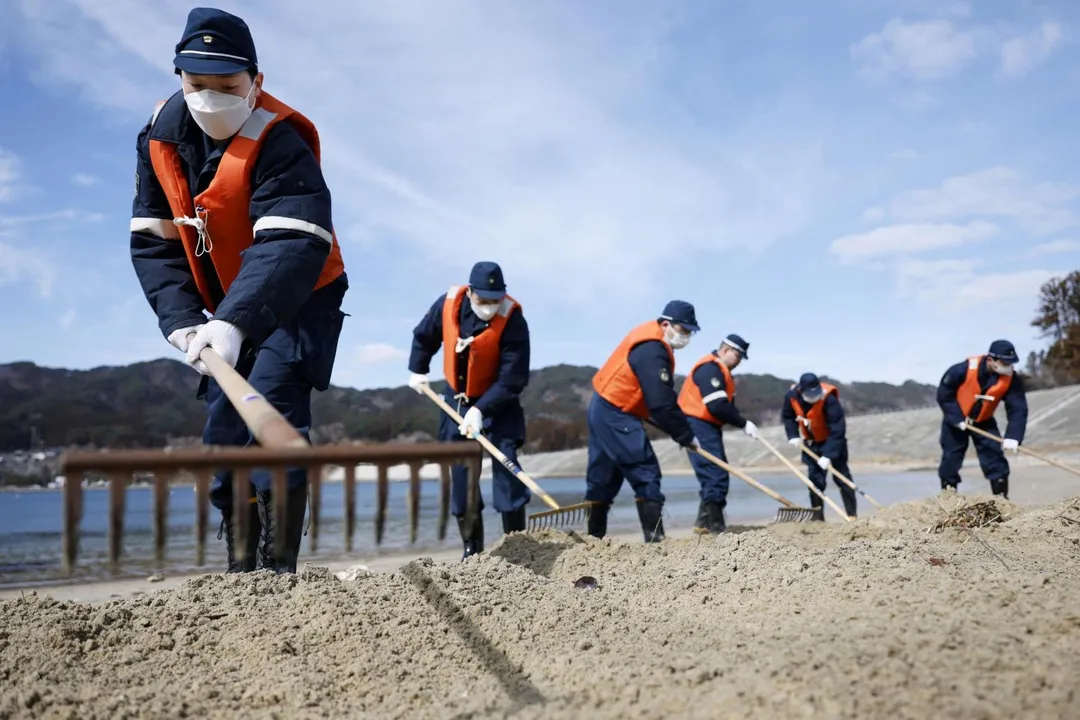 警方11日在日本岩手縣山田市海灘上搜尋2011年地震海嘯災難中失蹤人口的線索。（圖／《路透社》）