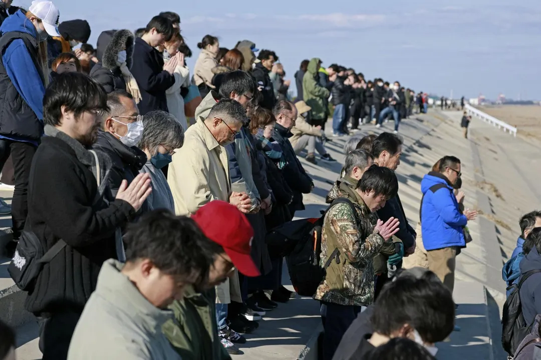 11日人們在日本宮城縣仙台市面向大海祈禱並默哀，紀念311地震15週年。（圖／《路透社》）