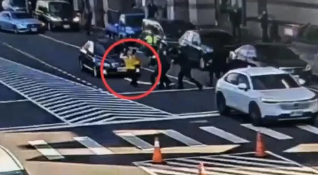 游智彬在民進黨中央黨部前丟雞蛋遭警方架離。（圖／翻攝畫面）