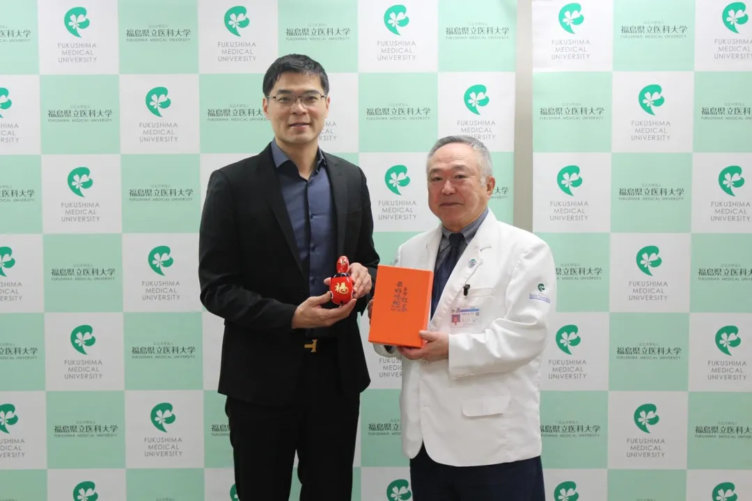 麗寶新藥總經理劉朝瀚與福島醫科大學校長竹之下誠一(Seiichi Takenoshita)互相交換台日伴手禮。(圖/麗寶新藥)