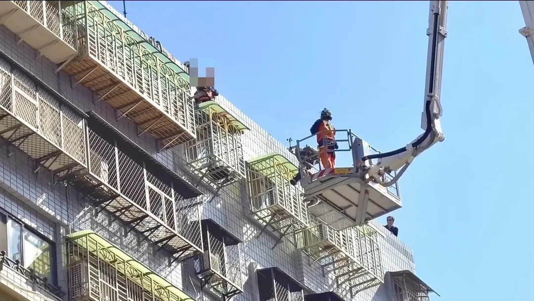警消人員爬上頂樓同時升起雲梯車救回女子。（圖／翻攝畫面）