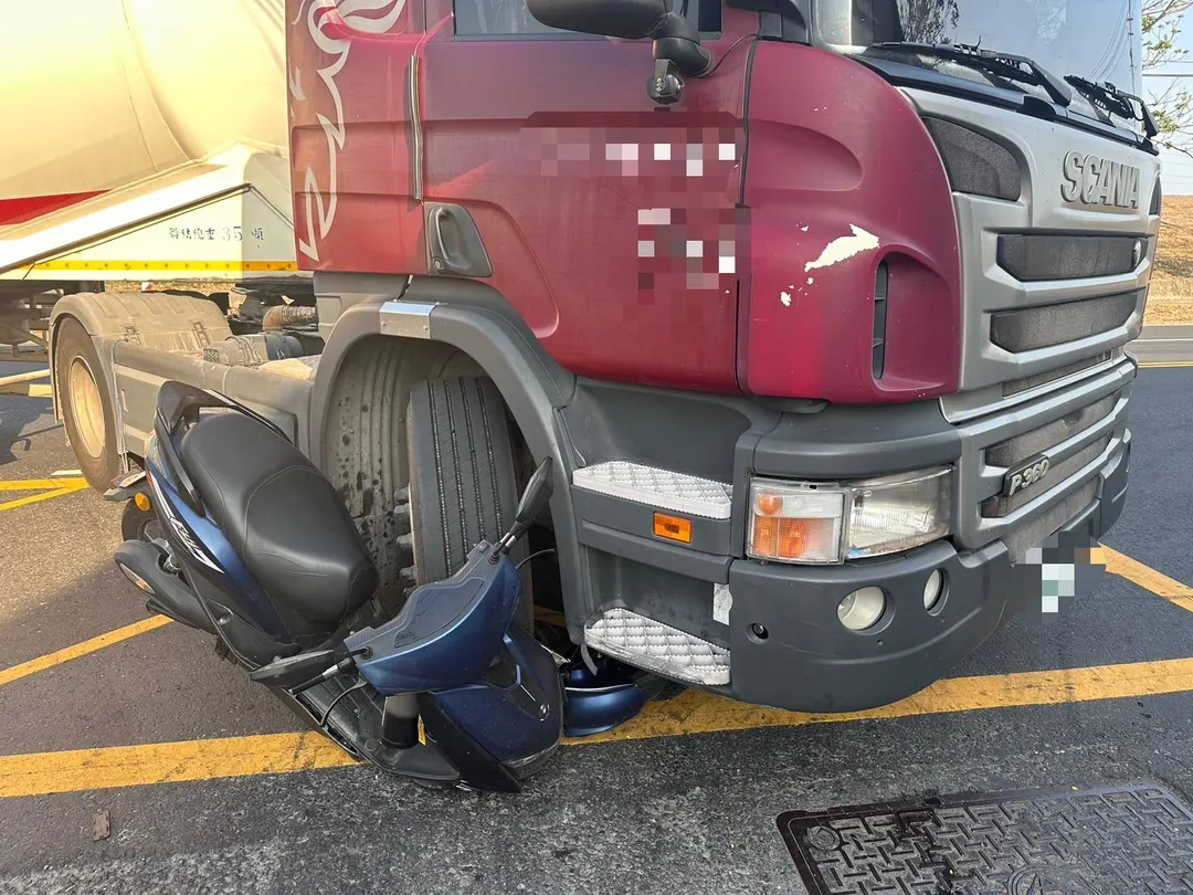 高雄市林園區工業二路17日下午發生一起驚悚車禍,一輛微型電動車與油罐車擦撞後,整輛機車竟被捲入油罐車右前輪下方,安全帽也掉落車底。(圖/翻攝畫面)