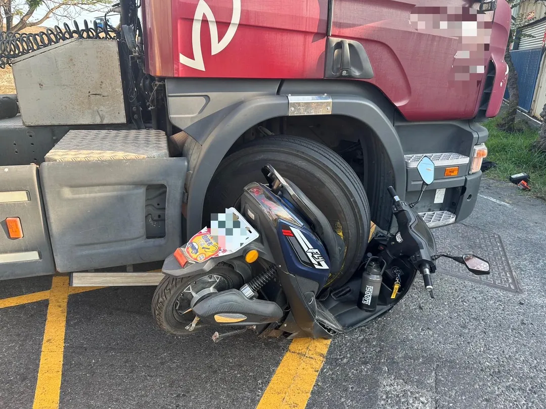 高雄市林園區工業二路17日下午發生一起驚悚車禍,一輛微型電動車與油罐車擦撞後,整輛機車竟被捲入油罐車右前輪下方,安全帽也掉落車底。(圖/翻攝畫面)