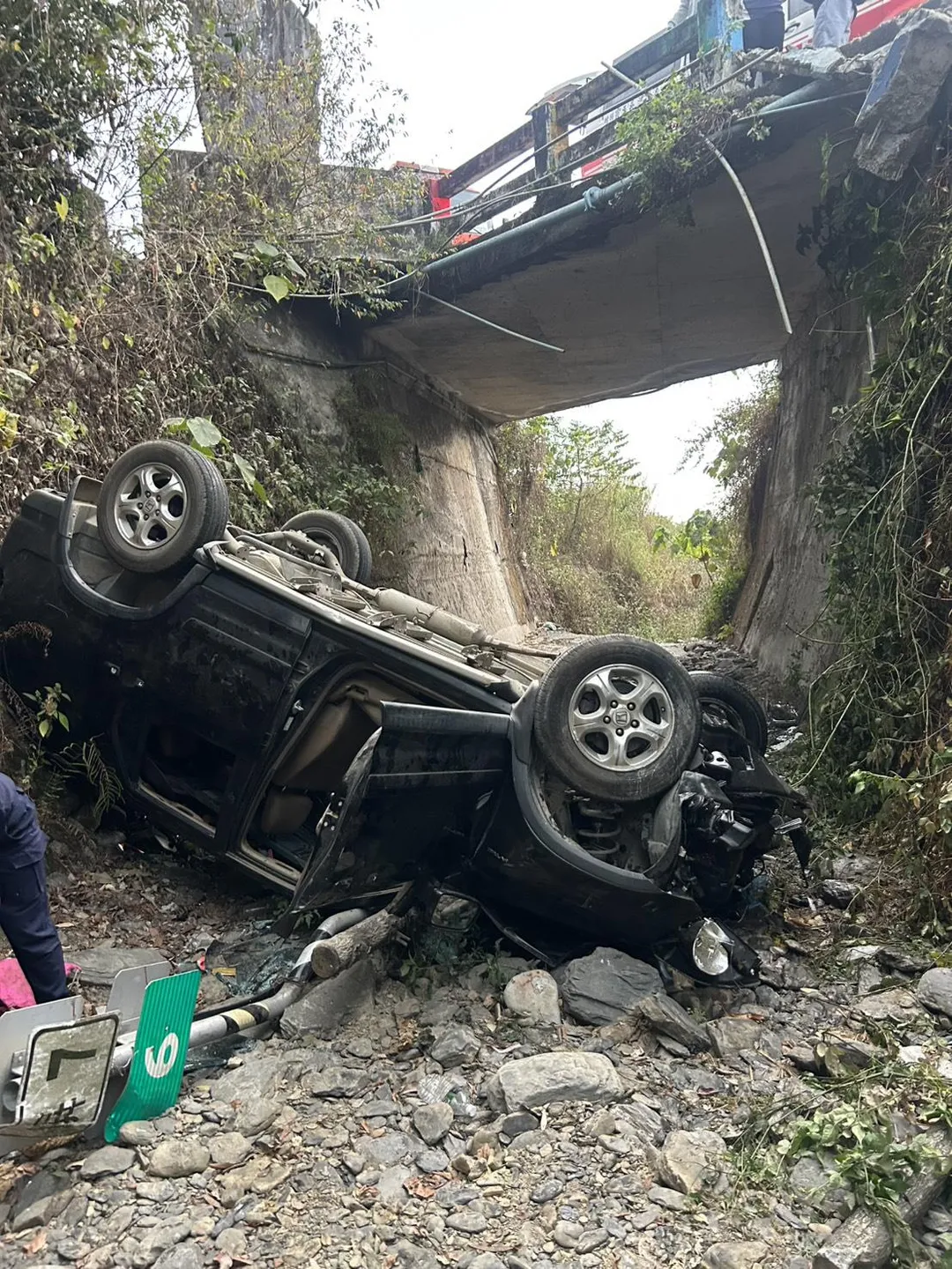 一輛休旅車疑似失控自撞後翻覆墜落橋旁大排水溝。（圖／警方提供）