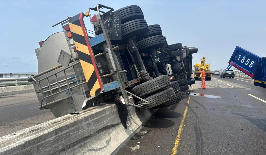 槽車遭撞翻卡在中央分隔島。（圖／翻攝畫面）